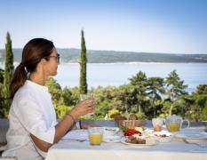 Eine Dame genießt das Frühstück im Hotel Kvarner Palace mit Blick aufs Meer