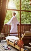 Ein Mann steht am Balkon des Saunadorfes im DAS RONACHER Thermal und Spa Resort