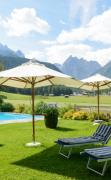 Garten des Hotels Drei Zinnen mit Schwimmbad und Liegen
